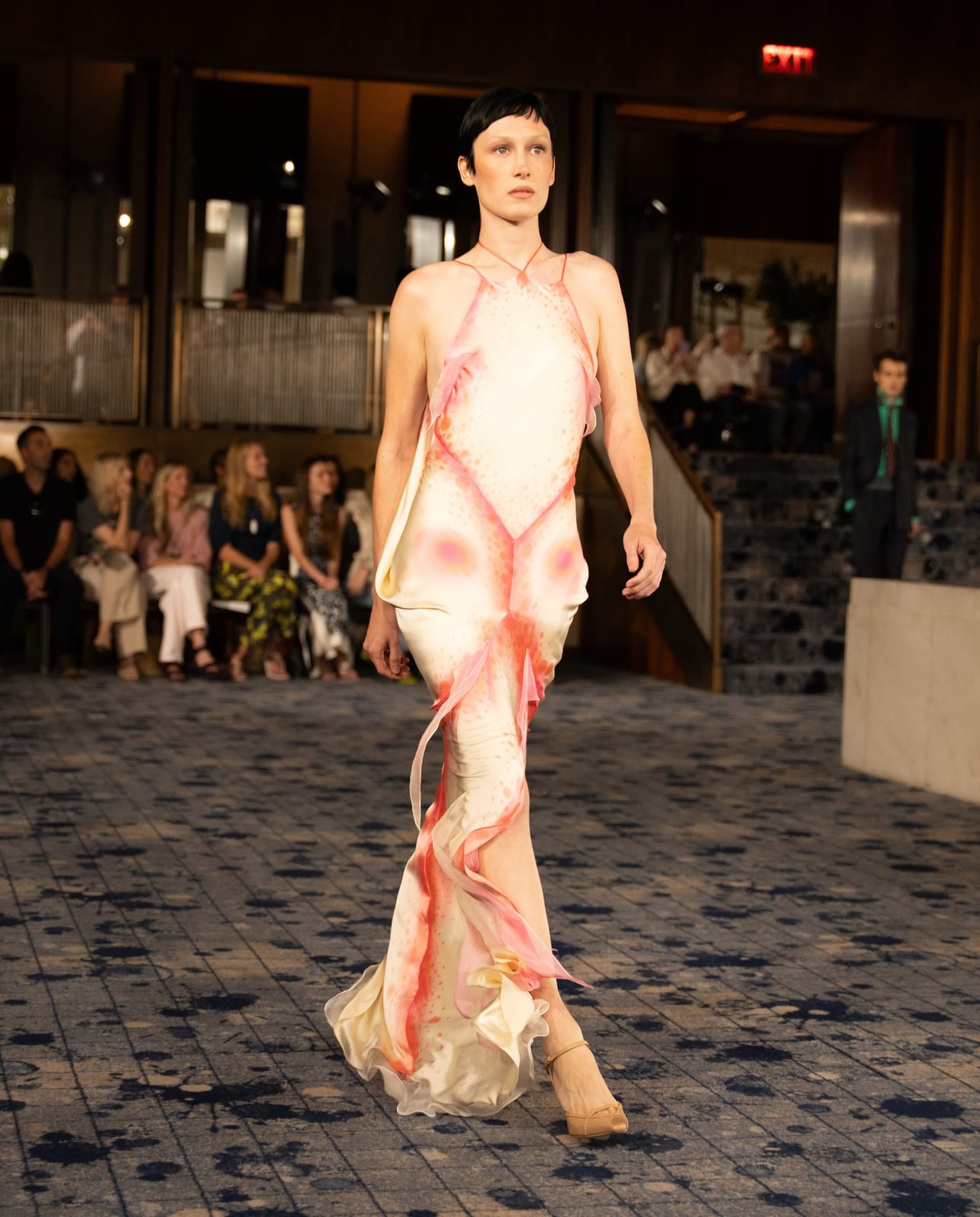 A cream silk halter gown hand-painted with a pink and red fish pattern, with ruffled trim, on the Conner Ives Spring 2027 runway
